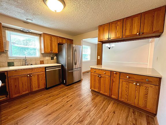 Kitchen with oak cabinets, fresh paint and stainless steel appliances.