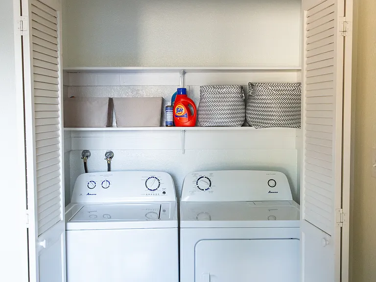 Side by side laundry with laundry supplies and baskets.