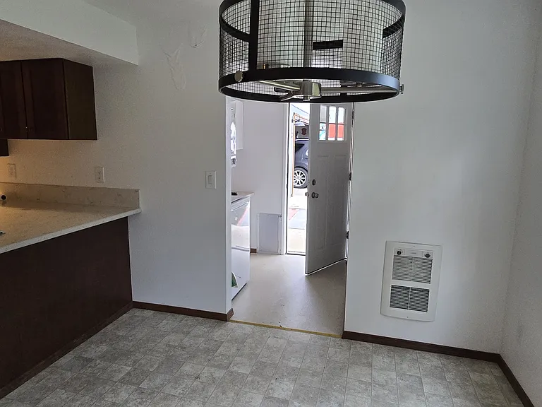 Standing in living room doorway looking at dining room into laundry room and back door.