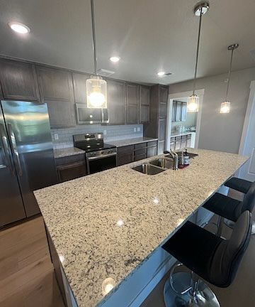 Upgraded kitchen with premium stainless-steel appliances, an externally vented microwave hood, and quality finishes