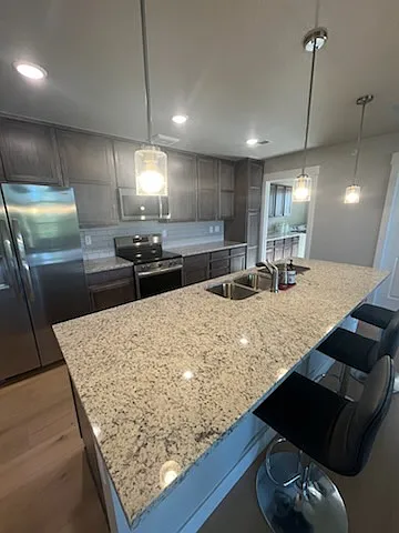 Upgraded kitchen with premium stainless-steel appliances, an externally vented microwave hood, and quality finishes