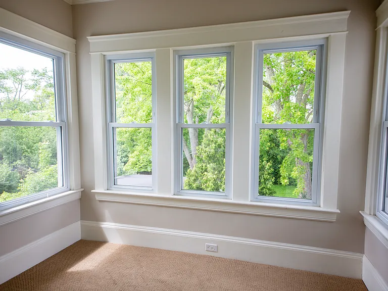 Bright bonus sunroom surrounded by windows _ ideal for a home office, reading nook, or creative retreat.