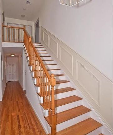 2 story entry foyer with open staircase and a chandelier.