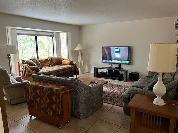 Living room with couches, daybed, TV, DVD player, modem and router. Cable TV has been discontinued but Internet for streaming is included.