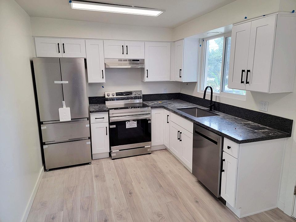 Bright kitchen with all new modern stainless steel appliances including dishwasher, honed charcoal granite counters, white/soft close cabinets, black hardware