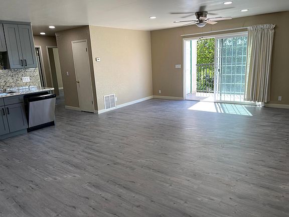 Large living room with ceiling fan and balcony access
