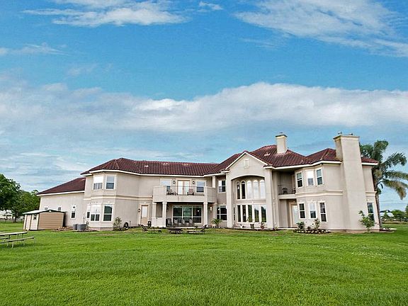 The back of the home was architecturally enhanced to provide greater appeal with two traditional masonry chimneys, an inset covered Porch, two Decks and the two story Living Room sheltered by massed columns and an arch above