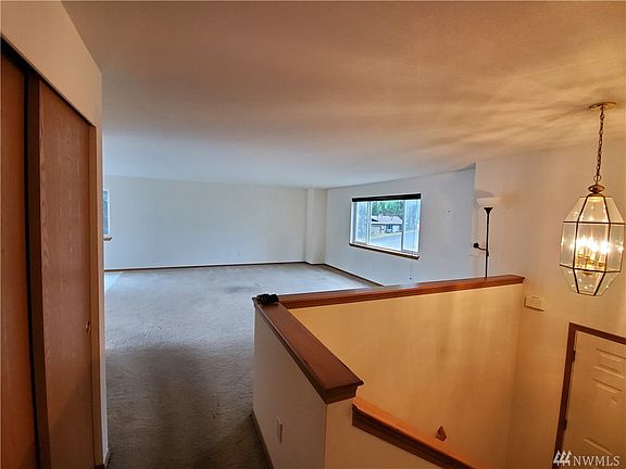 Split level entry with beautiful hardwood railings leads to the main living area, kitchen, dining room, master bedroom and 1st bedroom with main full bathroom.