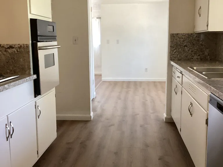 Kitchen with new stainless steel appliances and new granite counters.