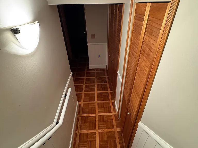 stairway to lower level, with wood parkay flooring