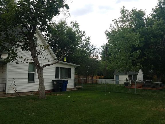 Extra large yard with small building in back. New deck in back under the tree.