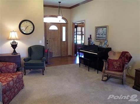 Large family room for entertaining.  Tall ceilings with crown molding and custom wood blinds.