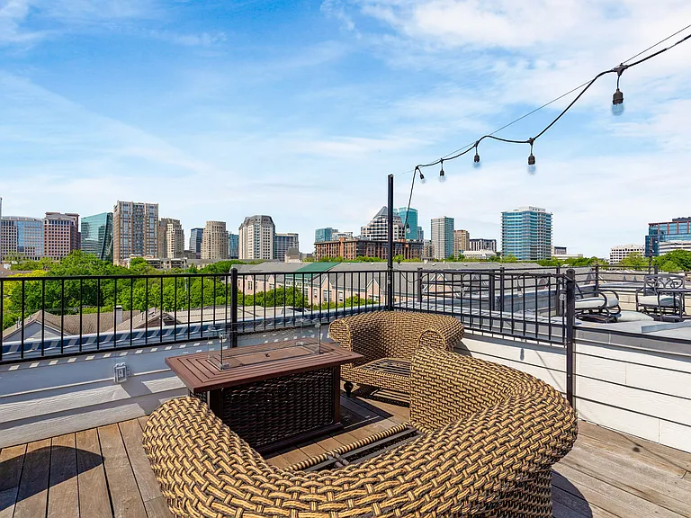 Cozy up by the fire pit while taking in the city lights on this stylish rooftop retreat.
