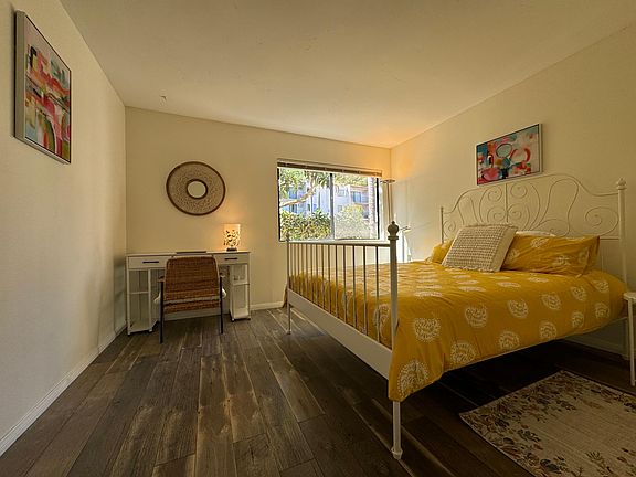 The bedroom has the perfect size for a queen bed and work area without taking all the space.
