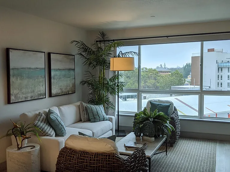 Cozy living area with oversized windows, wood_style plank flooring, and greenery creating a calming space for everyday comfort.