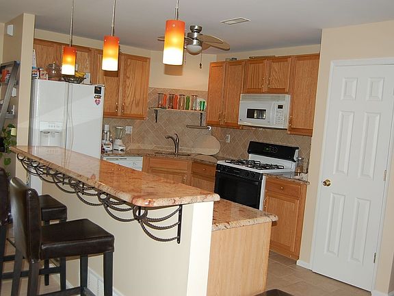 Gourmet Kitchen with granite countertop, tiled flooring and backsplash
