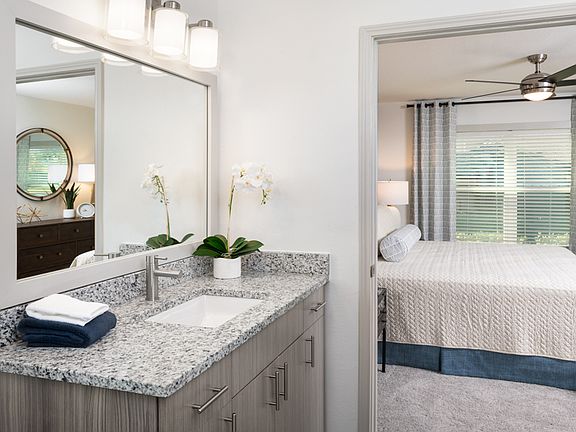 Remodeled bathrooms with wood grain cabinets and framed mirrors