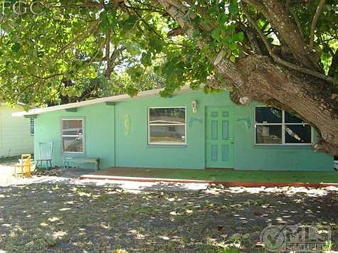 Front of house with patio and large shade tree