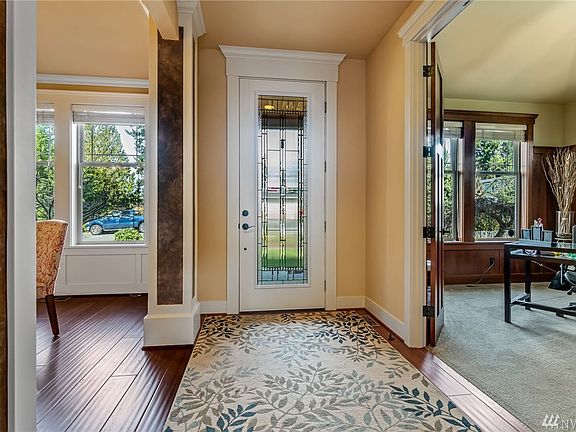 Broad, entry hallway opens to formal dining on the left and Cherry-paneled Den on the right.
