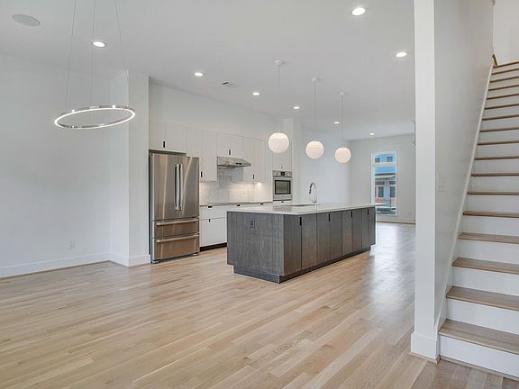 open and lofty dining area connects seamlessly to kitchen and living. Designer lighting