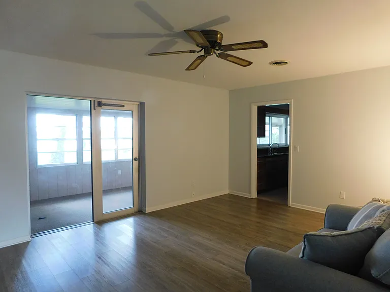 The ~18'x13' family room has one of the 3 ceiling fans. The large door leads to the porch area and the smaller door leads into the kitchen. We are facing northwest.