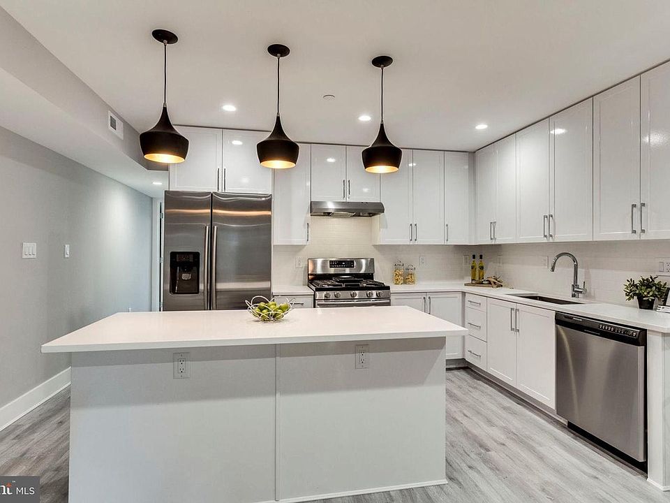 Bright white kitchen with large island and stainless steel appliances