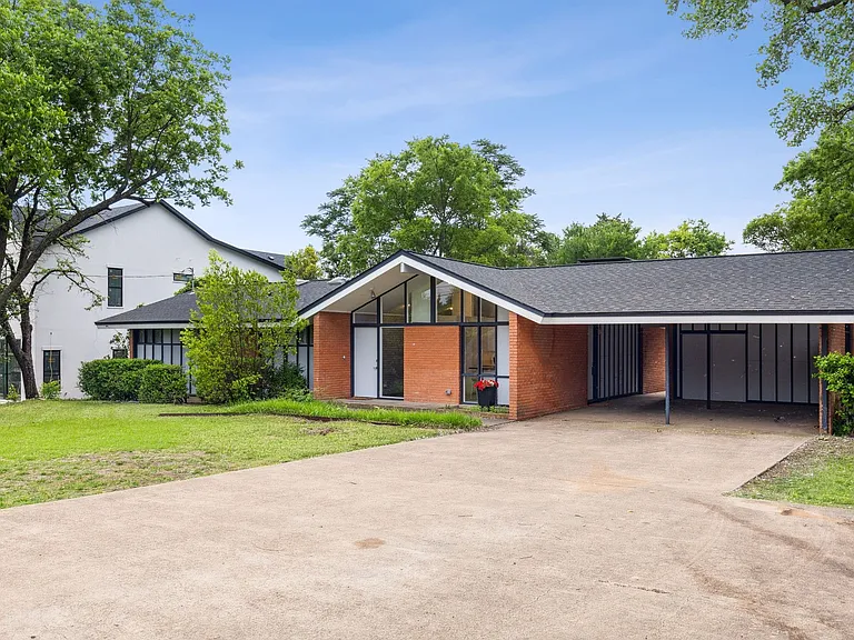Mid-century modern exterior featuring a prominent carport, brick facade, and a striking A-frame entry with large glass panels