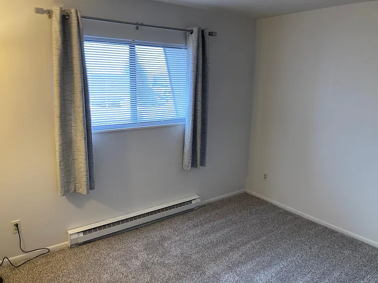 Large bedroom measures 12 by 14 feet. New mini blinds as well as drapes and electric baseboard heat with it own thermostat to keep the room comfortable.