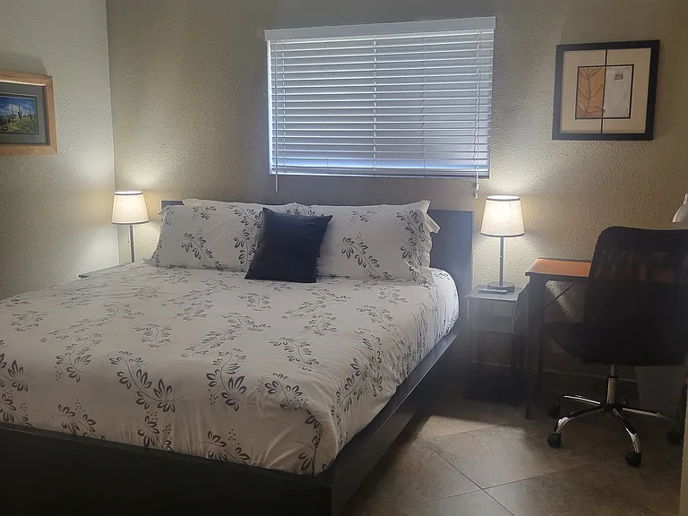 View from hallway to Master bedroom with King, nightstands and desk.