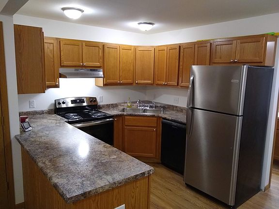 Kitchen with oak cabinets, oven, dishwasher, and refrigerator with ice maker