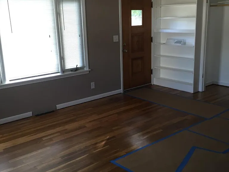 Living/ dining room polished wood floors and built in bookca
