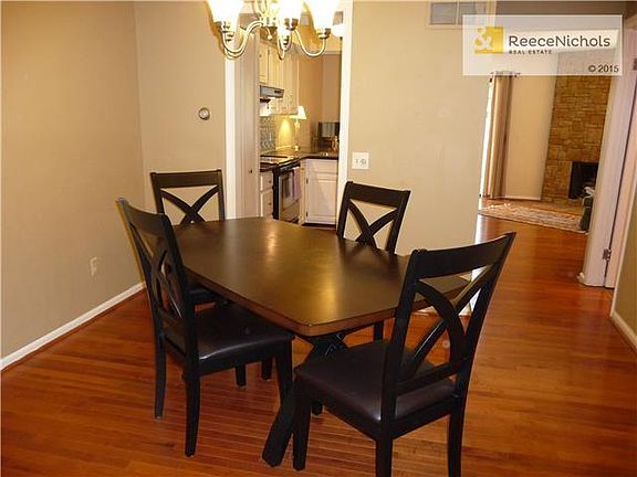 Dining room with hardwood floor opens to kitchen and hearth room.