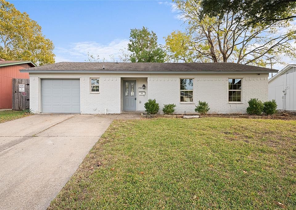 Single story home featuring a front yard and a garage