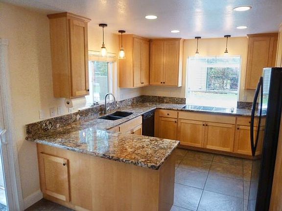 Bright kitchen with granite counter tops and garden window