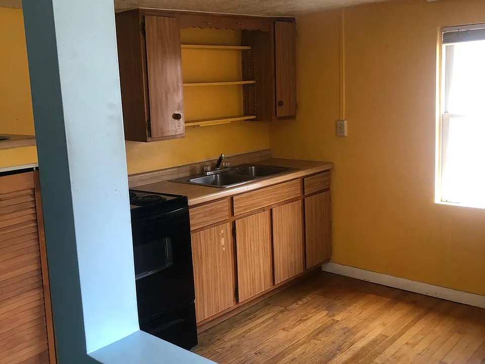 A separated kitchen with room to have a table and chairs.