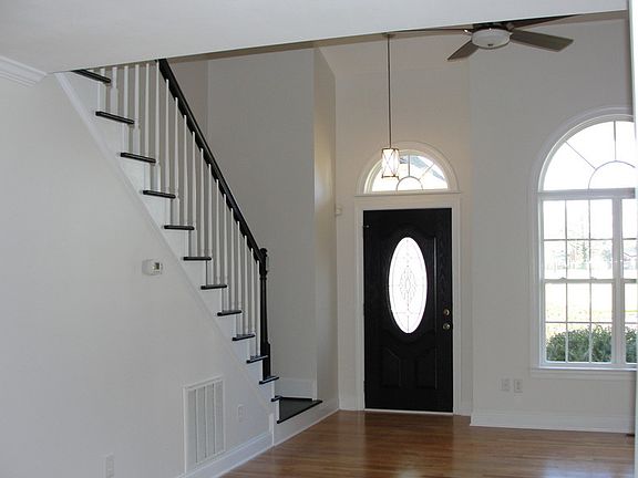 View into living room : Wide custom painted staircase. Cathedral ceiling.