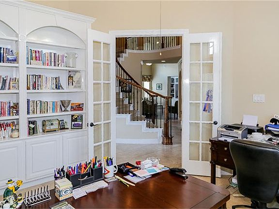 Double French doors open to the study where you will find high ceilings, fan, and a wall of built-ins
