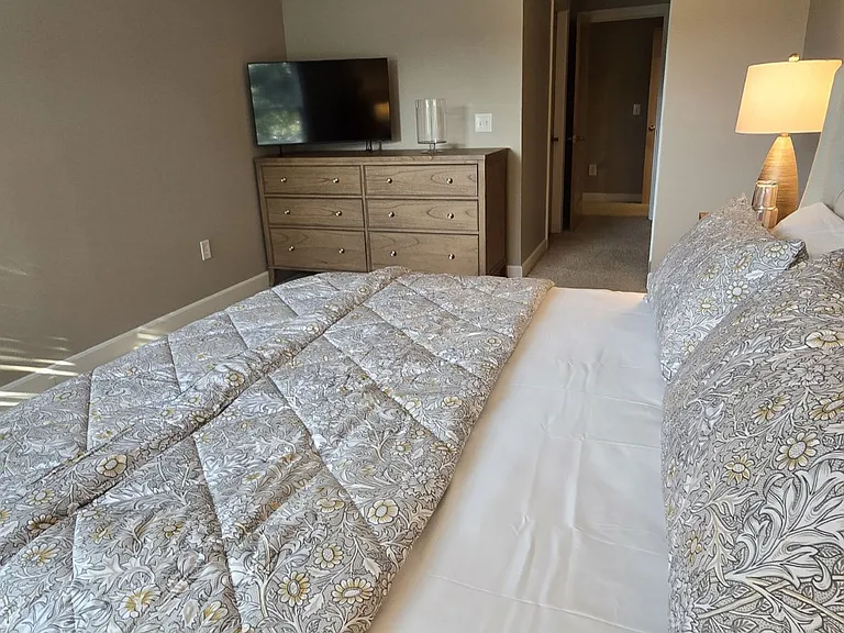 Private bedroom with King size upholstered bed, (2) night stands, large dresser and double closet, ceiling fan with light, new 43" Samsung Smart TV.