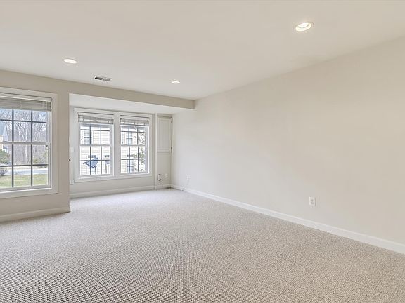 Large rec room (or home office) with carpet and recessed lights. Access to the backyard.