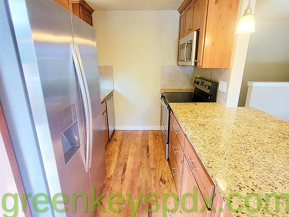 Galley kitchen with granite counters, stainless steel appliances