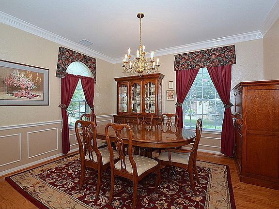 The elegant formal dining room has a chandelier and the same attractive real wood flooring found in 