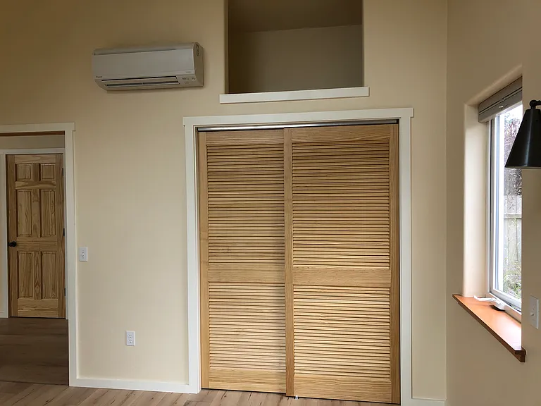 The bedroom closet with extra storage above, and one of the mini split heat pumps.