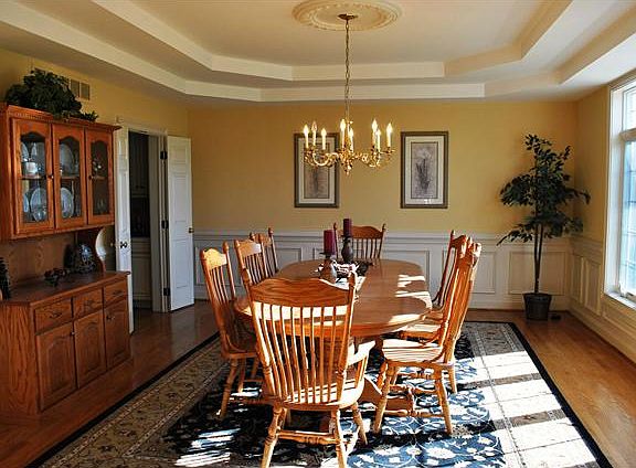 Large dining room featuring tray ceiling.