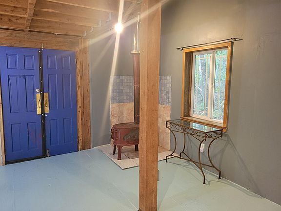 Part of living room with former woodstove. Updated with energy efficient propane unit with blower.