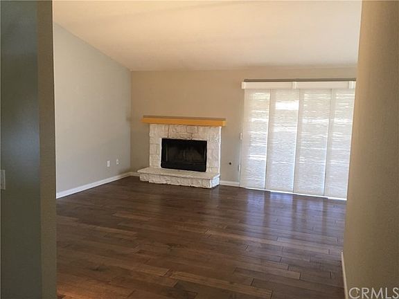 Living room with fireplace and view to the golf course behind the window treatment