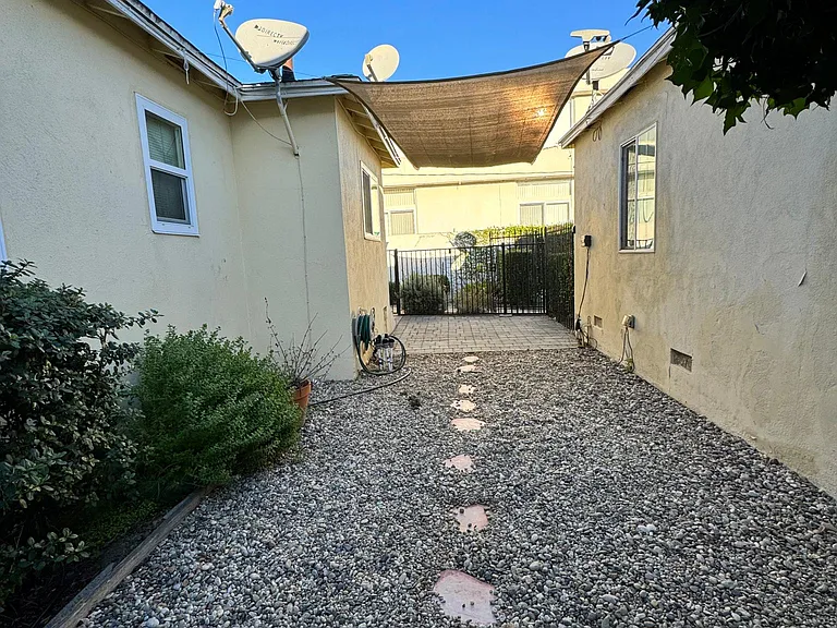 Private, gated, outdoor patio with seating area, garden, and space for outdoor storage