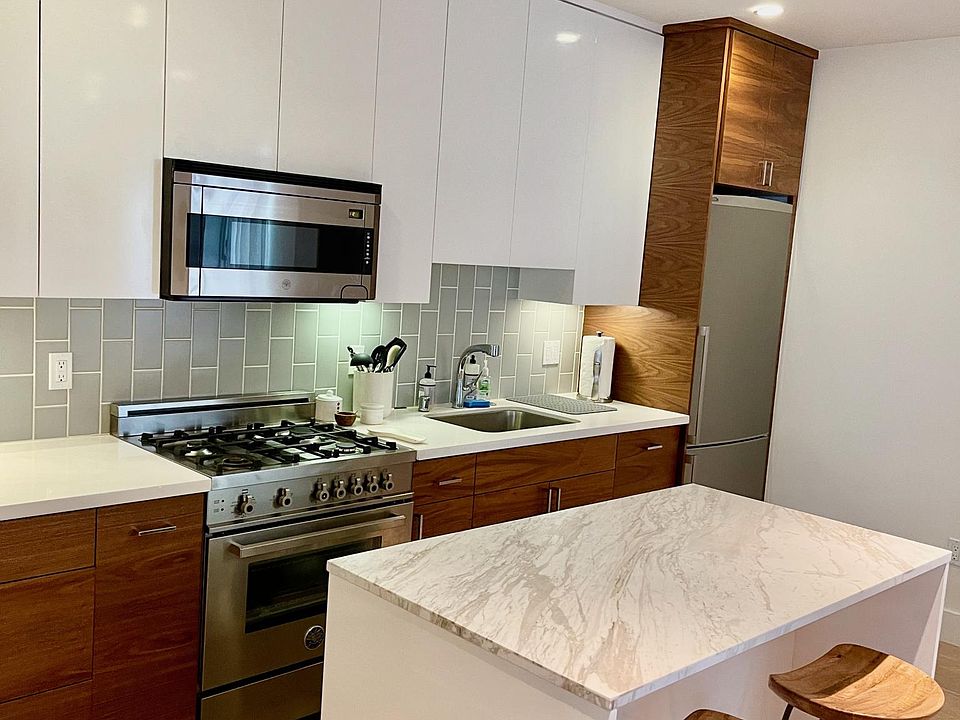 Beautiful kitchen with quartz-stone counters and island, custom kitchen cabinetry, and state-of-the-art stainless steel appliances (Bertazzoni gas stovetop, oven, and microwave; Bosch refrigerator and dishwasher)