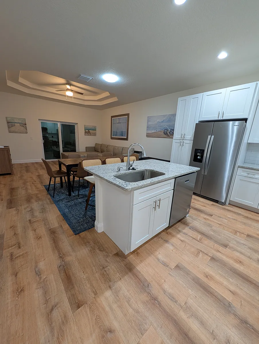 Kitchen with island featuring 3 counter stools and a dining area with 8 chairs. - 10 Lloleeta Path