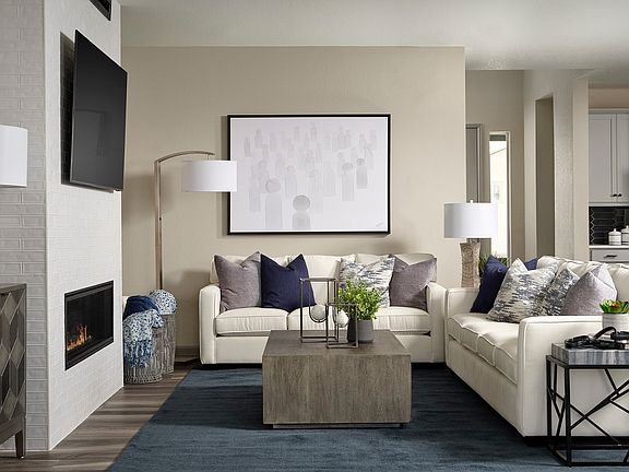 A cozy and stylish living room with a fireplace, plush sofas, and a modern coffee table, set against