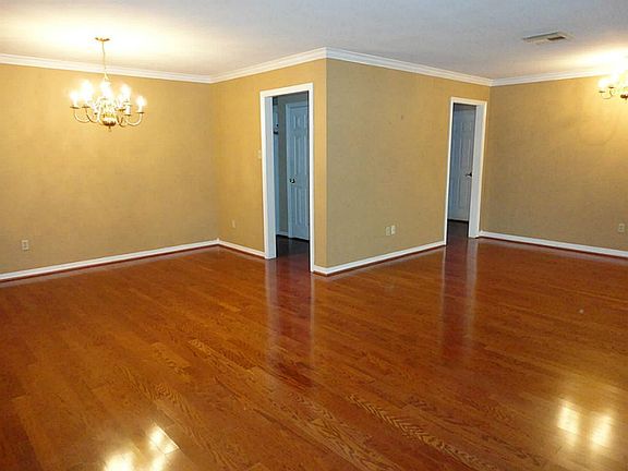 Open floor plan is showcased by crown molding, gleaming hardwoods and floor to ceiling windows.
